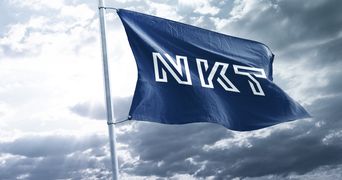 NKT flaf flying in the wind with grey sky